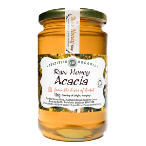 Large labelled glass jar containing 1kg of golden raw organic acacia honey