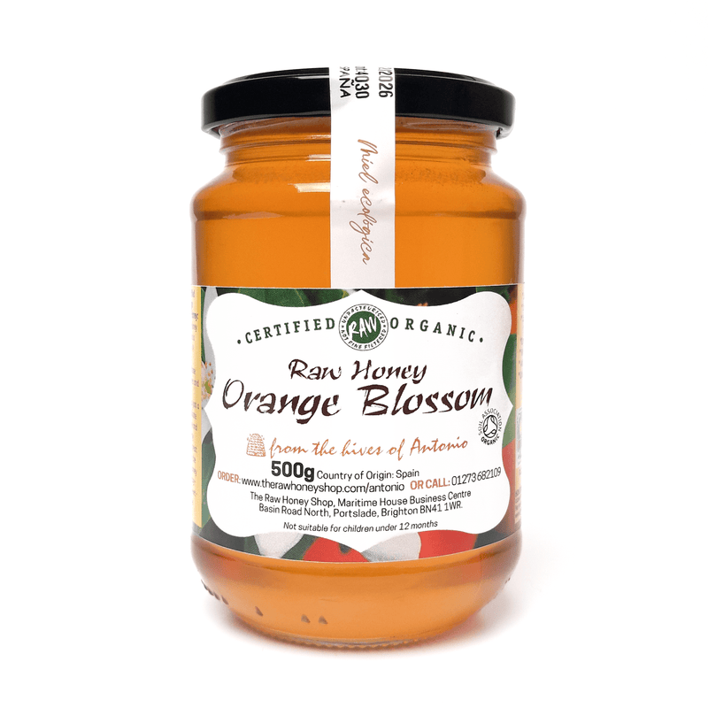 Glass jar containing 500g of raw organic orange blossom honey