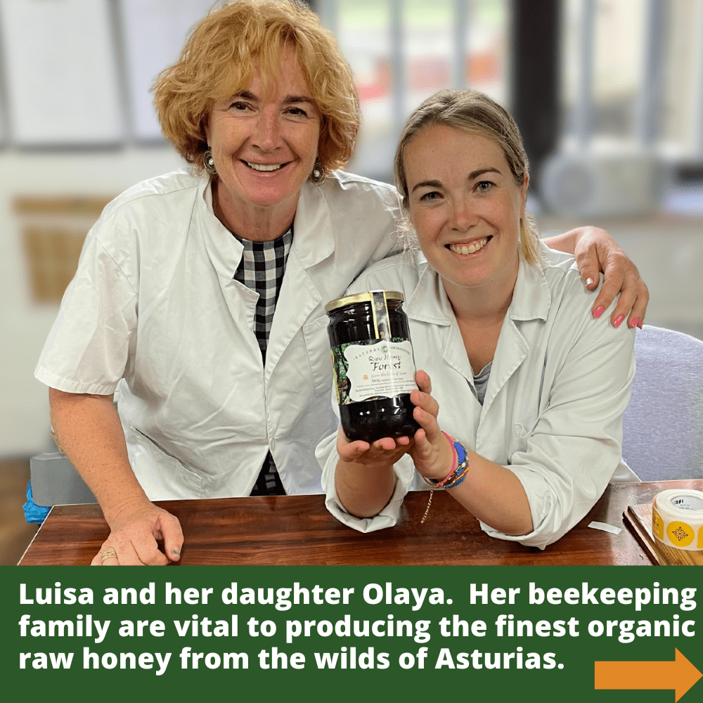 Beekeepers Luisa and her daughter Olaya in white coats. Olaya holds large glass jar of dark honey.