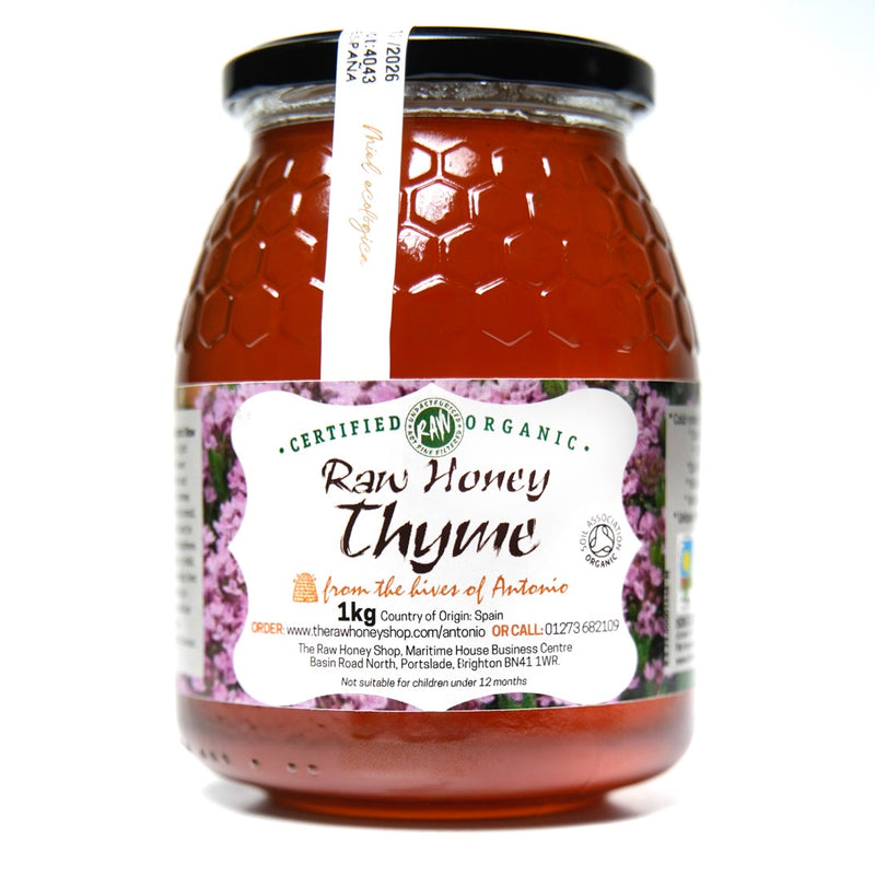 Large glass jar containing 1kg of raw organic thyme honey