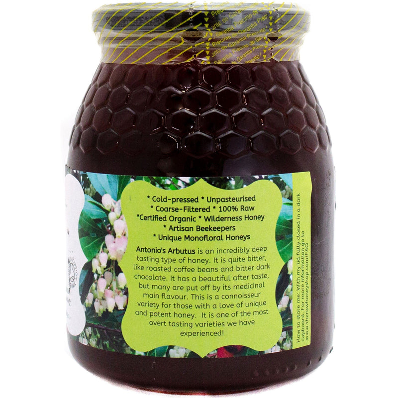 large glass jar of dark arbutus honey showing label on back of jar