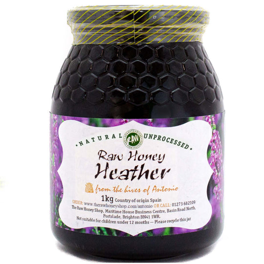 Large labelled glass jar containing 1kg of dark raw heather honey.